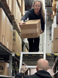 Dans le magasin, chez Aéro Atelier, Vanessa Mongrain s'apprête à donner une boite de cylindre Lycoming à Guy Blais.