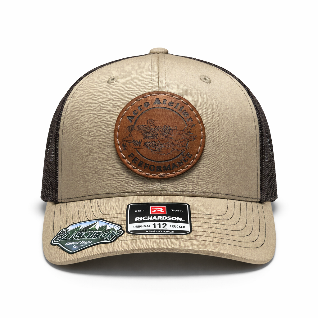 Portez l'héritage d'Aéro Atelier avec cette casquette Richardson 112 au coloris Khaki et Café. Elle arbore un écusson en cuir véritable gravé du logo original imaginé par Guy-Paul Mongrain pour représenter nos moteurs à performance accrue. Designée localement, cette pièce unique allie la robustesse du style « Trucker » à une finition artisanale sobre et technique, idéale pour le travail au hangar comme pour le vol.